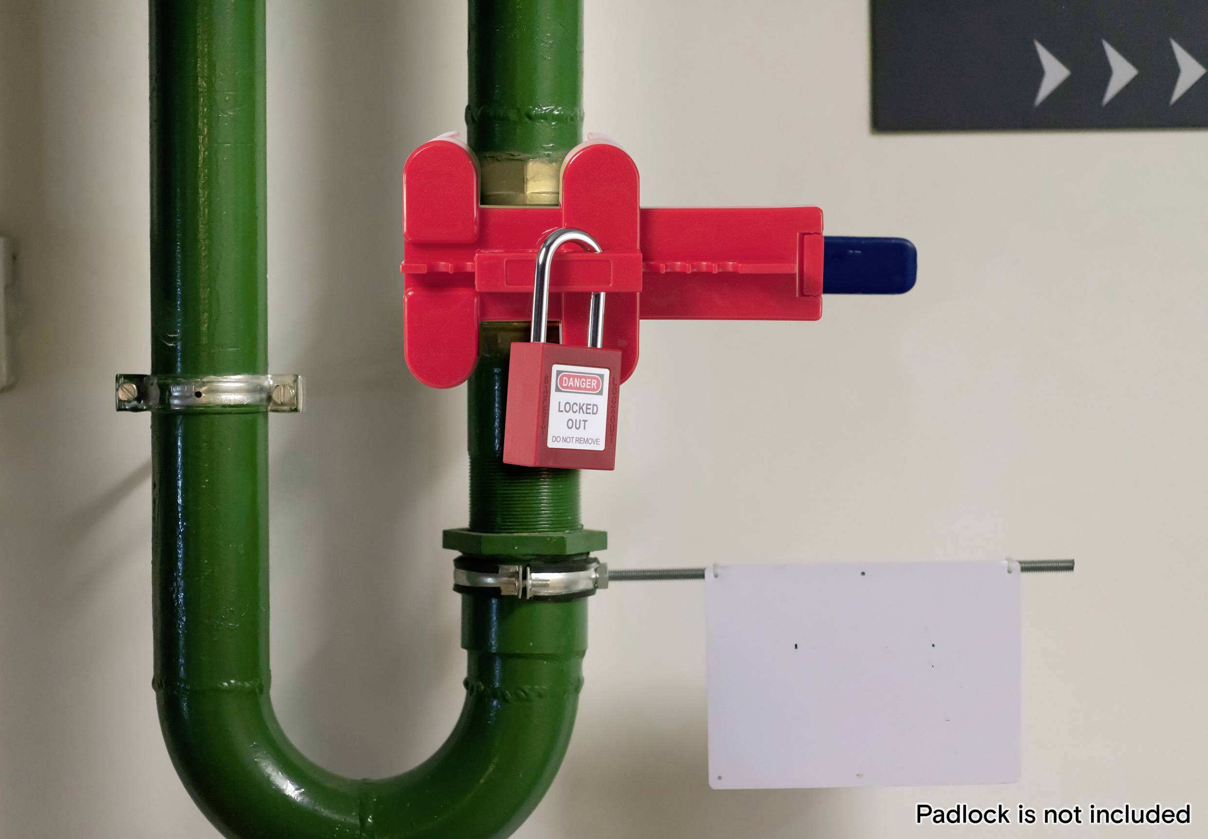 Ein grünes Industrierohr mit einer roten Sperrvorrichtung und einem Sicherheitsetikett mit der Aufschrift "Gesperrt". Ein leeres Schild ist angebracht, und das Vorhängeschloss fehlt.