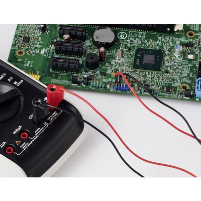 Ein Multimeter, das mit einer Leiterplatte verbunden ist und einen Testaufbau für elektronische Komponenten und Diagnosen zeigt.