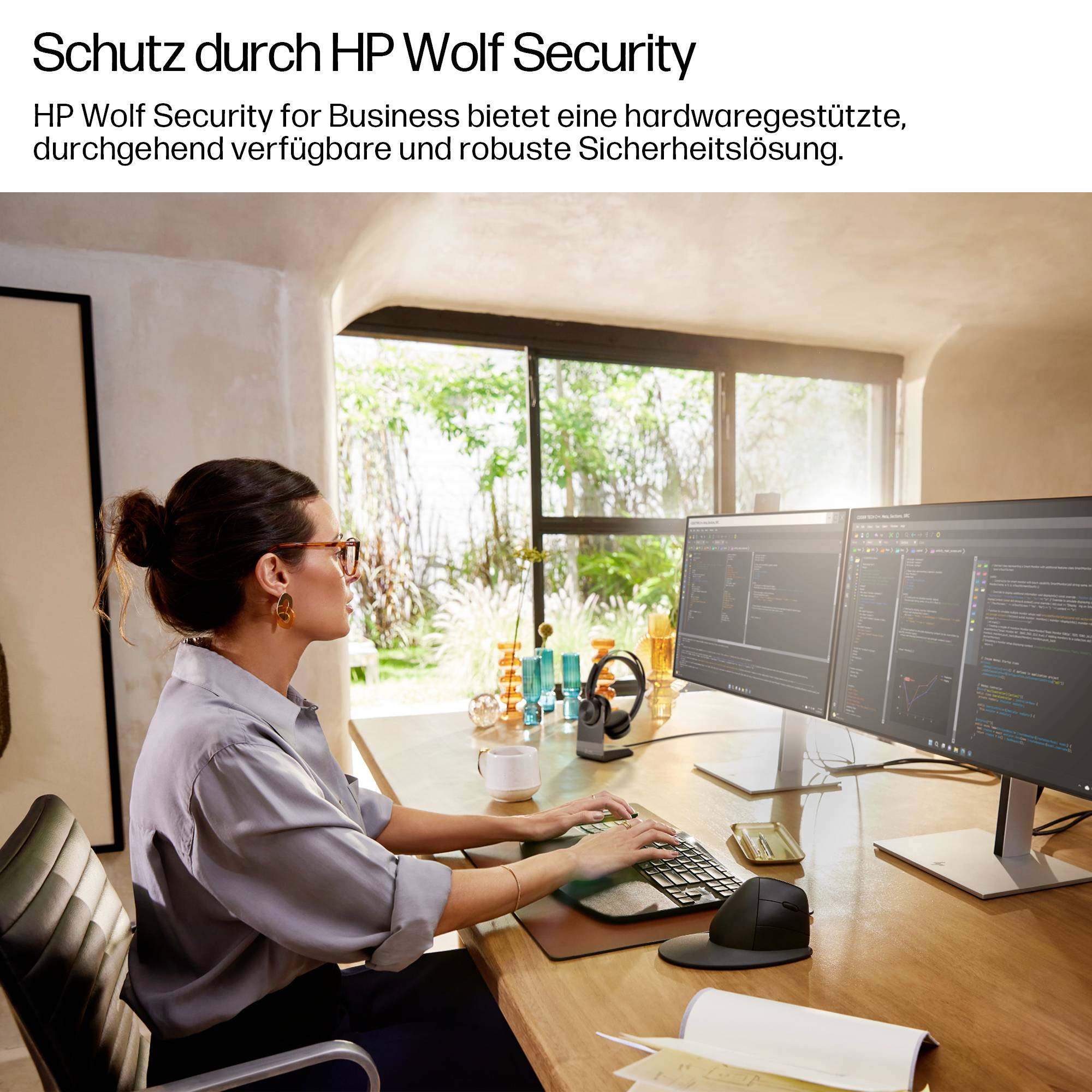 Eine Frau in einem Büroumfeld arbeitet an zwei Monitoren, die Sicherheitssoftware zeigen und dabei 'HP Wolf Security for Business' hervorheben.