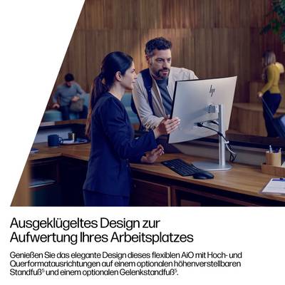 Eine Frau und ein Mann diskutieren über Arbeit in einem Büro in der Nähe eines Desktop-Computers. Der Text auf Deutsch bewirbt ein flexibles, elegantes Arbeitsplatzdesign.