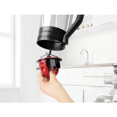 Eine Hand hält eine rote Rührschaufel unter ein Bosch-Küchengerät, bereit zum Anbringen. Die Küche ist mit weißen modernen Schränken ausgestattet.