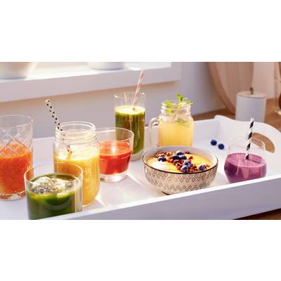 Ein Tablett mit bunten Smoothies in verschiedenen Gläsern und Gefäßen sowie eine Schüssel Smoothie, die mit Beeren garniert ist, steht auf einem sonnigen Tisch.