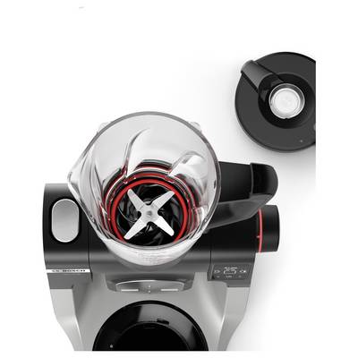 Eine Draufsicht eines Standmixers mit einem geöffneten Glaskrug, in dem sich die Klingen befinden. Der Deckel liegt neben dem Mixer.