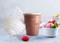 Eiscreme-Maschine mit Eiszapfen-Design und Waffel-gemustertem Behälter. Daneben eine weiße Schüssel mit knallig pinker Eiscreme und Erdbeeren.