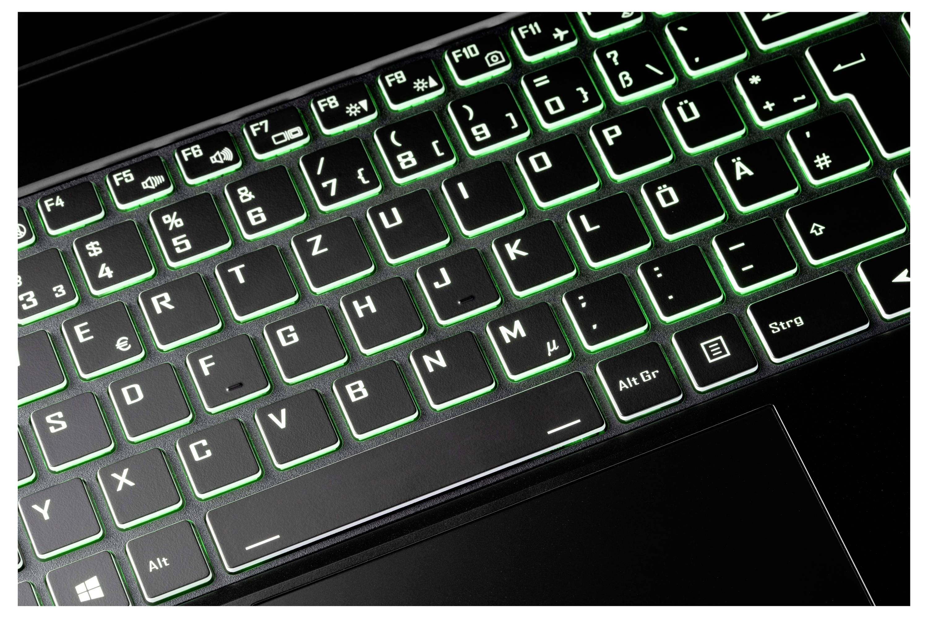 Eine Tastatur mit Hintergrundbeleuchtung und grüner Beleuchtung, deren Tasten sowohl in Standard- als auch in deutschen Sonderzeichen beschriftet sind, einschließlich Umlaute.