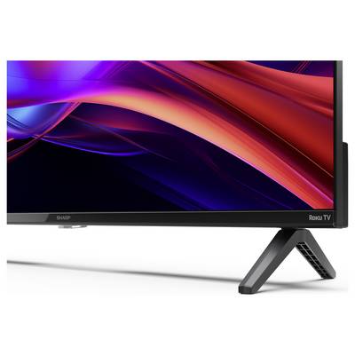 Eine Nahaufnahme der Ecke eines Sharp Roku Fernsehers, die einen eleganten schwarzen Rahmen und einen modernen Standfuß zeigt, und sein stilvolles Design betont.