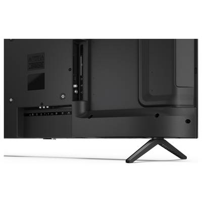 Die Rückseite eines Flatscreen-Fernsehers mit verschiedenen Anschlüssen, darunter HDMI und USB, wobei ein Ständer die untere rechte Ecke stützt.