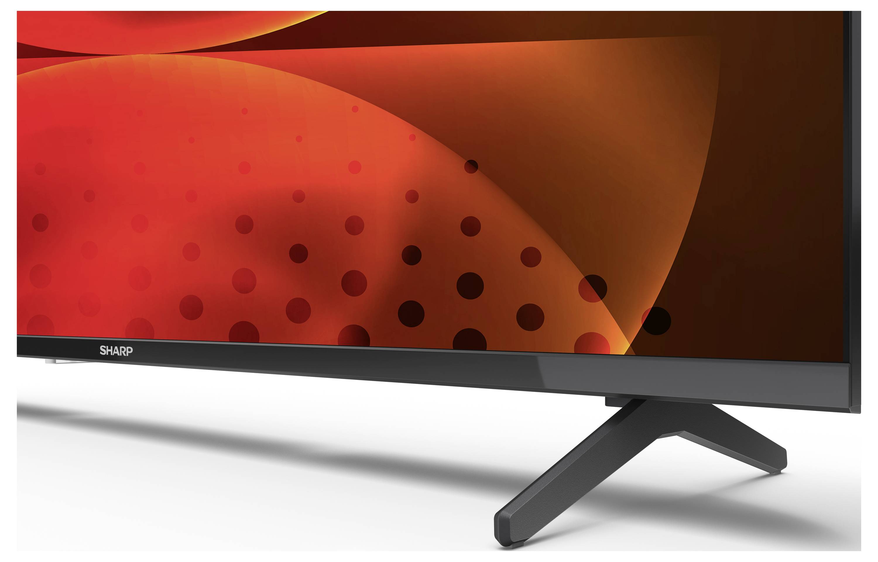 Ein Flachbild-Fernseher mit einem rot-schwarzen abstrakten Muster auf dem Bildschirm, versehen mit schlanken schwarzen Beinen zur Unterstützung.