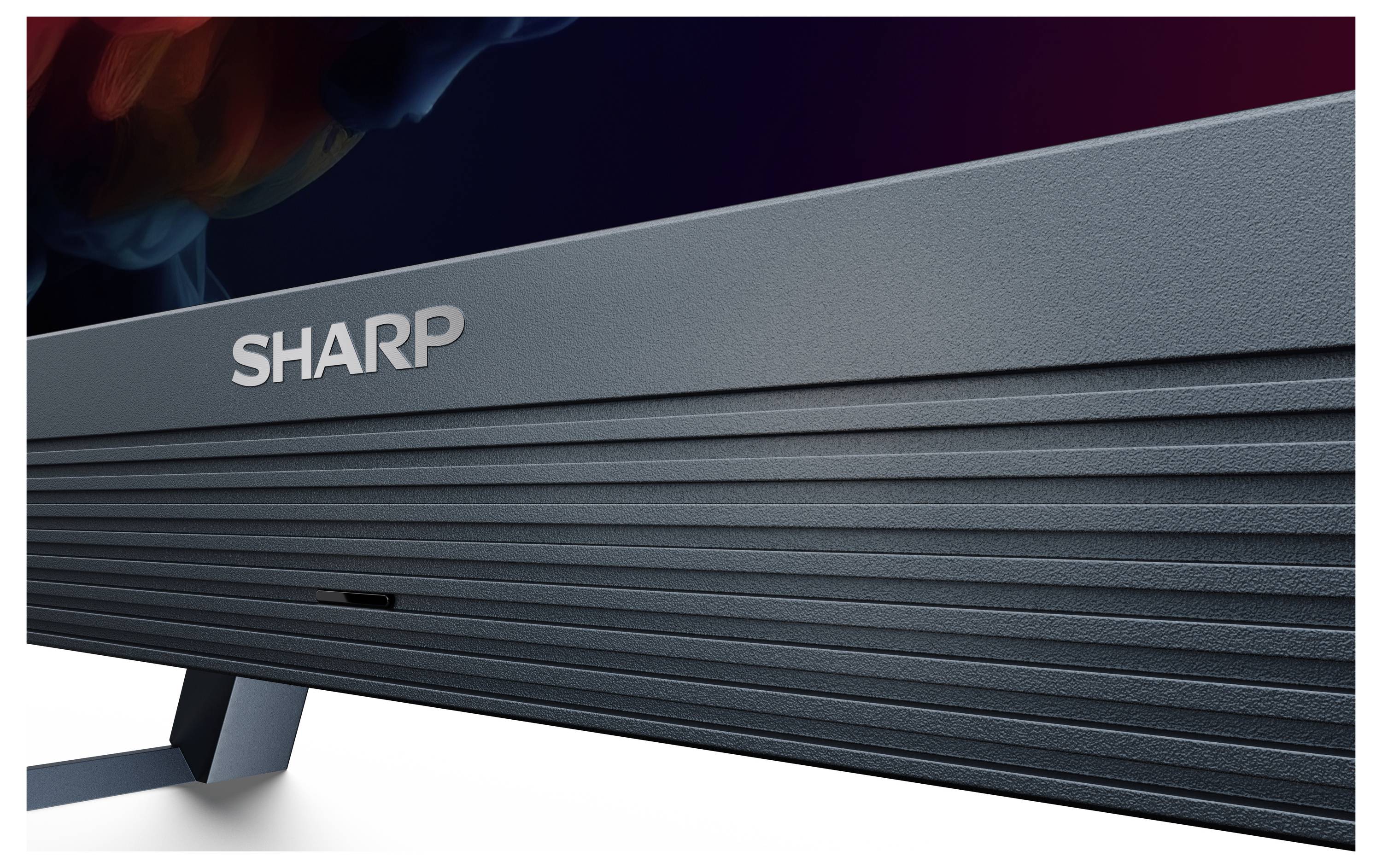 Nahaufnahme des unteren Rahmens und Ständers eines Sharp-Fernsehers, die das Markenlogo und die strukturierte Oberfläche hervorheben.