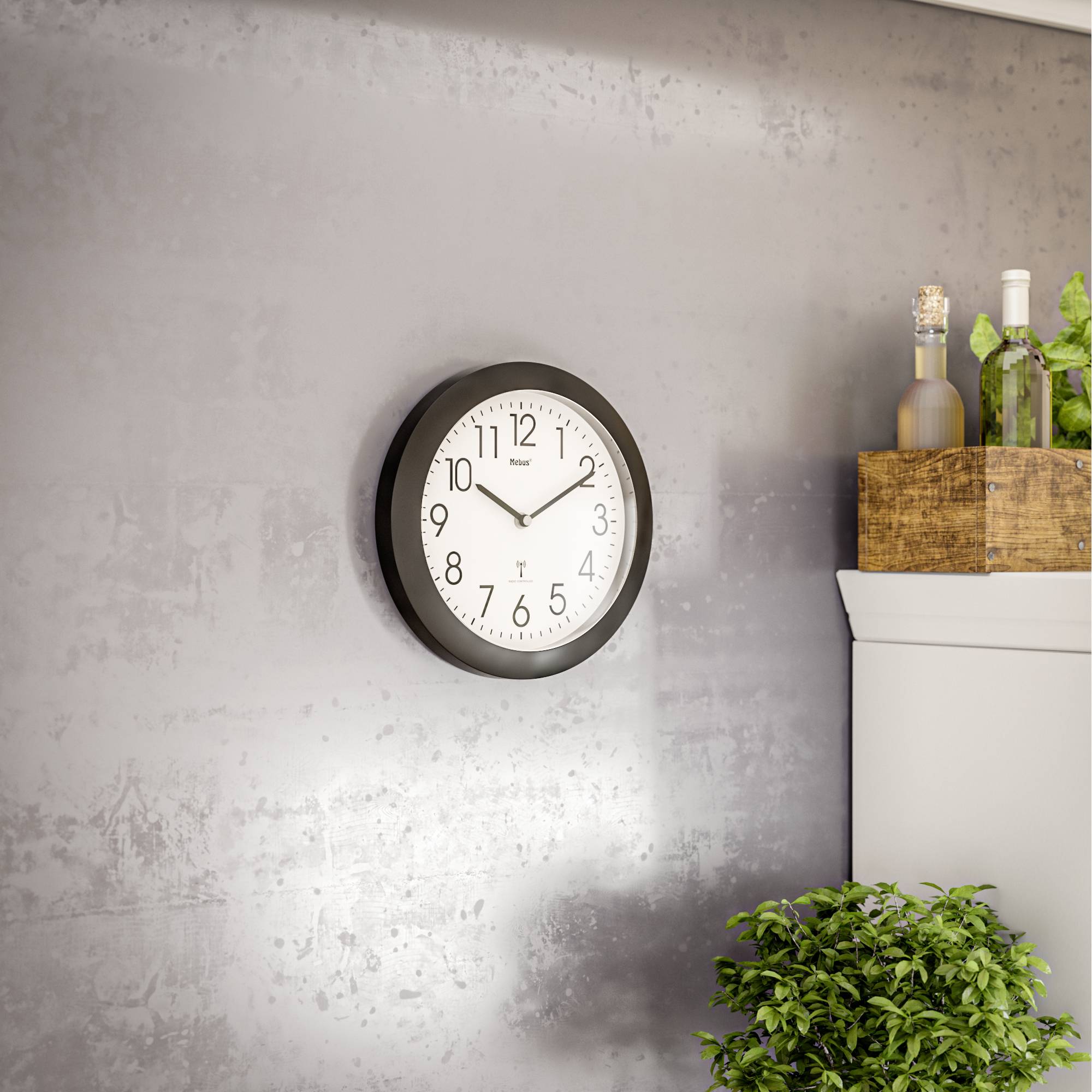 Eine runde Wanduhr zeigt 10:09 Uhr. Sie hängt an einer grauen Wand über einer Topfpflanze, mit dekorativen Flaschen im Hintergrund.