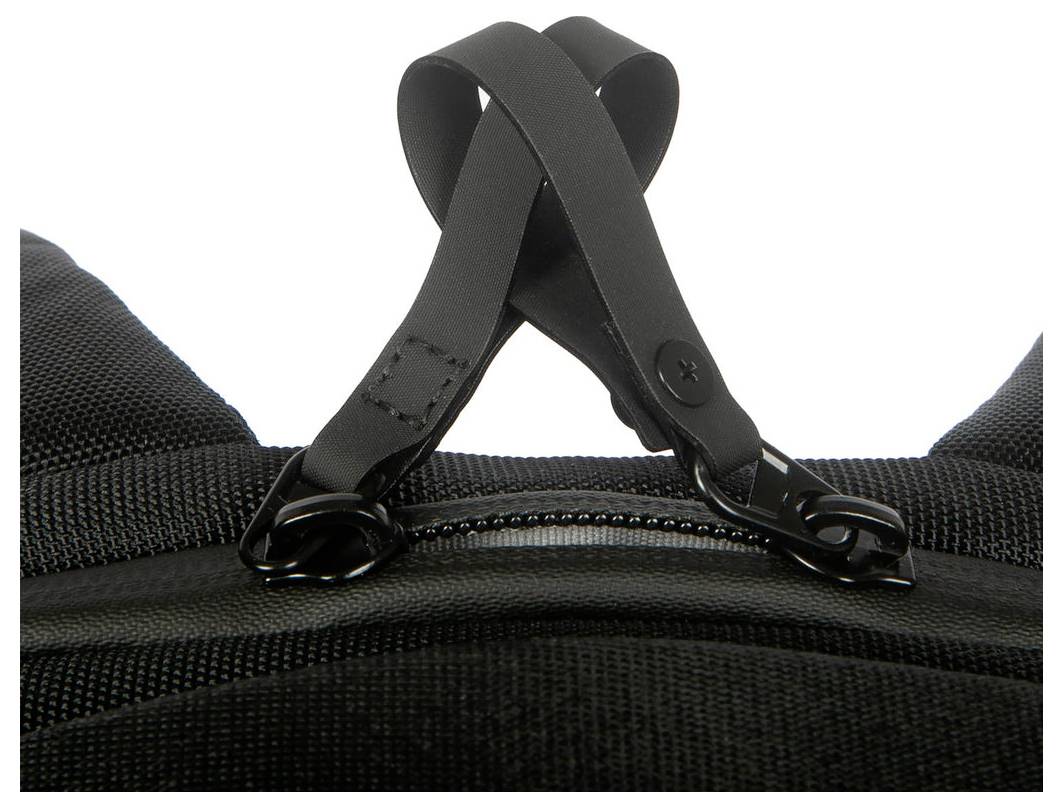Nahaufnahme von schwarzen Taschengriffen, die an einem Reißverschlussschieber an einem schwarzen strukturierten Rucksack befestigt sind.