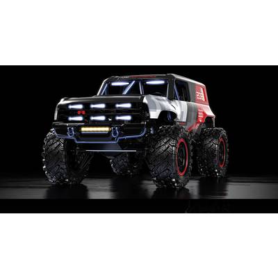 Ein großer, futuristischer Monstertruck mit überdimensionalen Reifen und hellen LED-Leuchten auf einer reflektierenden schwarzen Oberfläche.