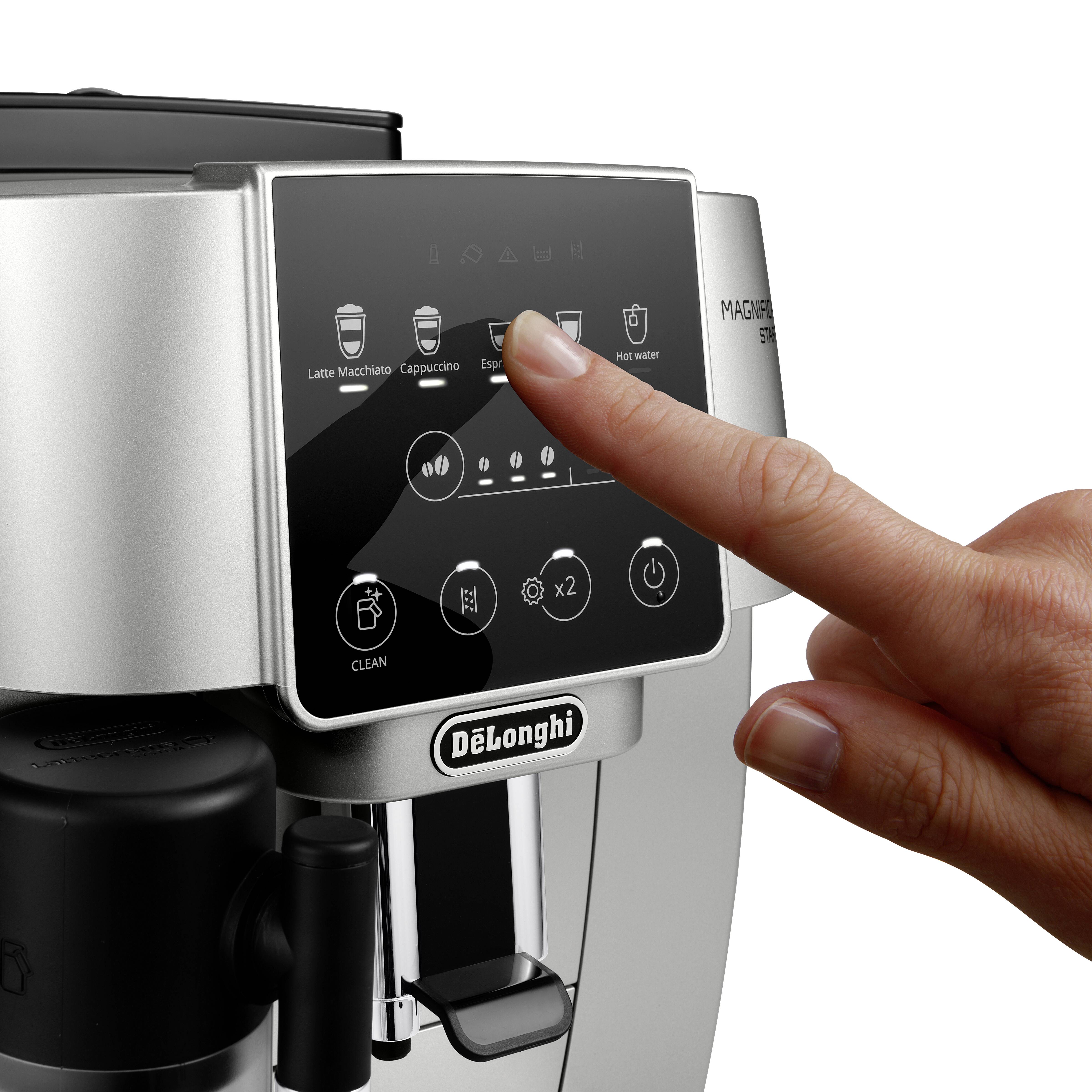 Eine Hand berührt den digitalen Bildschirm einer DeLonghi Magnifica Kaffeemaschine und wählt Optionen wie Espresso und Heißwasser aus.