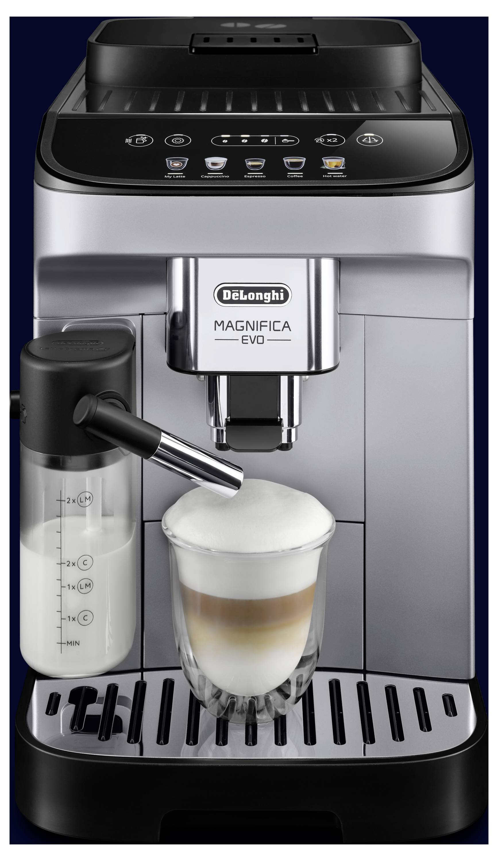 Eine De'Longhi Magnifica Evo Kaffeemaschine, die eine Tasse Cappuccino mit Schaum in ein Glas einschenkt, neben einem Milchaufschäumbehälter.
