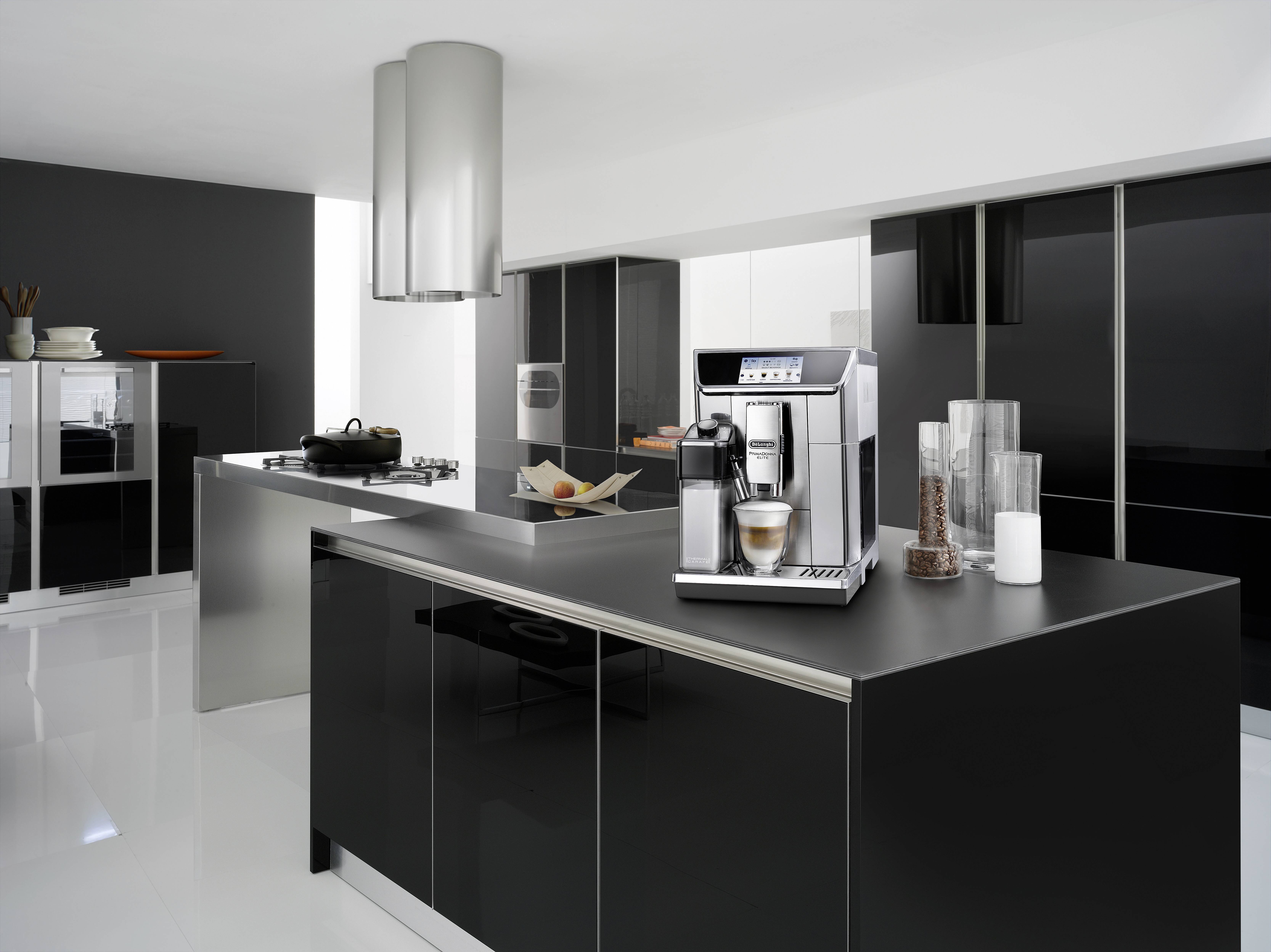 Eine moderne Küche mit eleganten schwarzen Schränken und einer Kücheninsel in der Mitte. Eine Kaffeemaschine ist prominent auf der Arbeitsplatte platziert.