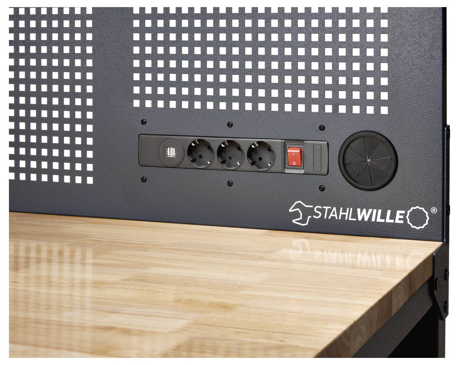 Eine Werkbank mit einer hellholzfarbenen Oberfläche verfügt über eine schwarze Platte mit drei Stromsteckdosen, einem Netzschalter und einem Markenlogo.