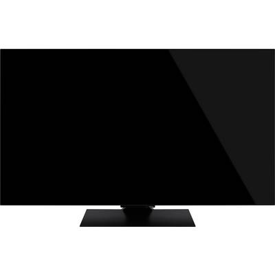 Ein großer, schwarzer Flachbildschirm-Fernseher, ausgeschaltet, auf einem rechteckigen Ständer platziert, vor einem schlichten Hintergrund.
