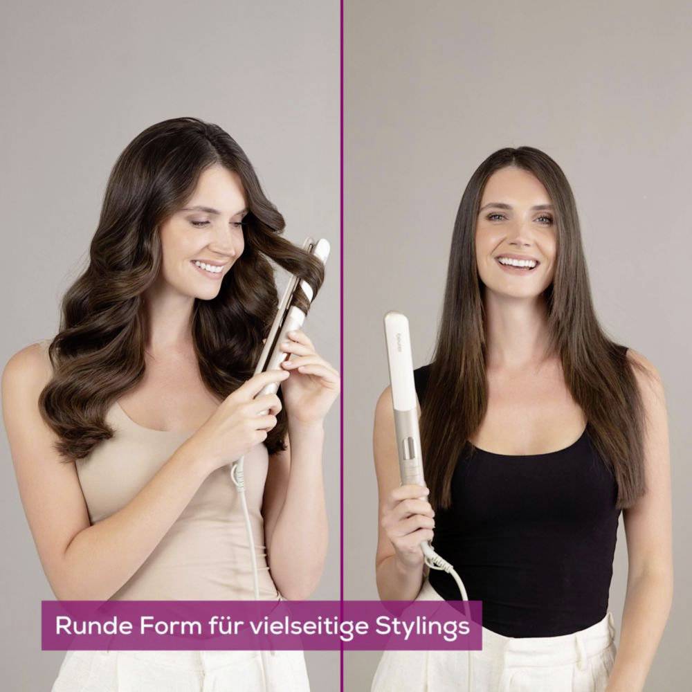 Zwei Frauen mit langen Haaren, die Haarstyling-Werkzeuge benutzen. Eine hält ein Lockenstab und die andere einen Glätteisen, beide lächeln in die Kamera.