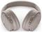 Noise-Cancelling Over-Ear-Kopfhörer in einer hellen Beige-Farbe, mit schlankem Design, verstellbarem Kopfbügel und Bedienungstasten an der Seite.