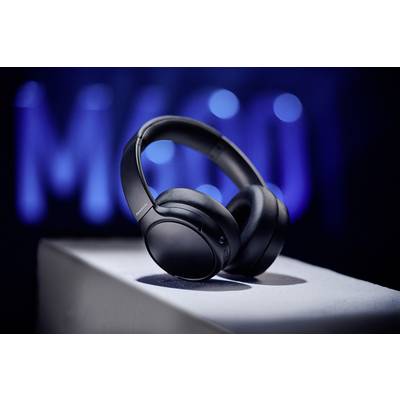 Schwarze Over-Ear-Kopfhörer auf einem weißen Podest, mit unscharfem blauem Hintergrund. Der Fokus liegt auf den Kopfhörern.