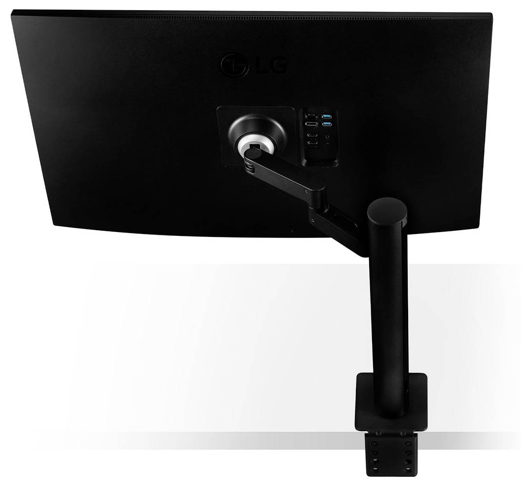 Ein schwarzer Computermonitor, der an einem verstellbaren Arm befestigt ist, der an einem Schreibtisch montiert ist, wobei die Kabelführung und die Anschlussports auf der Rückseite hervorgehoben werden.