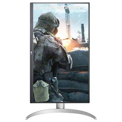 Ein Soldat in Ausrüstung ist auf dem Bildschirm eines vertikalen LG UHD-Monitors 4K zu sehen, der hinter einer Barriere steht, während im Hintergrund eine feurige Explosion zu sehen ist.