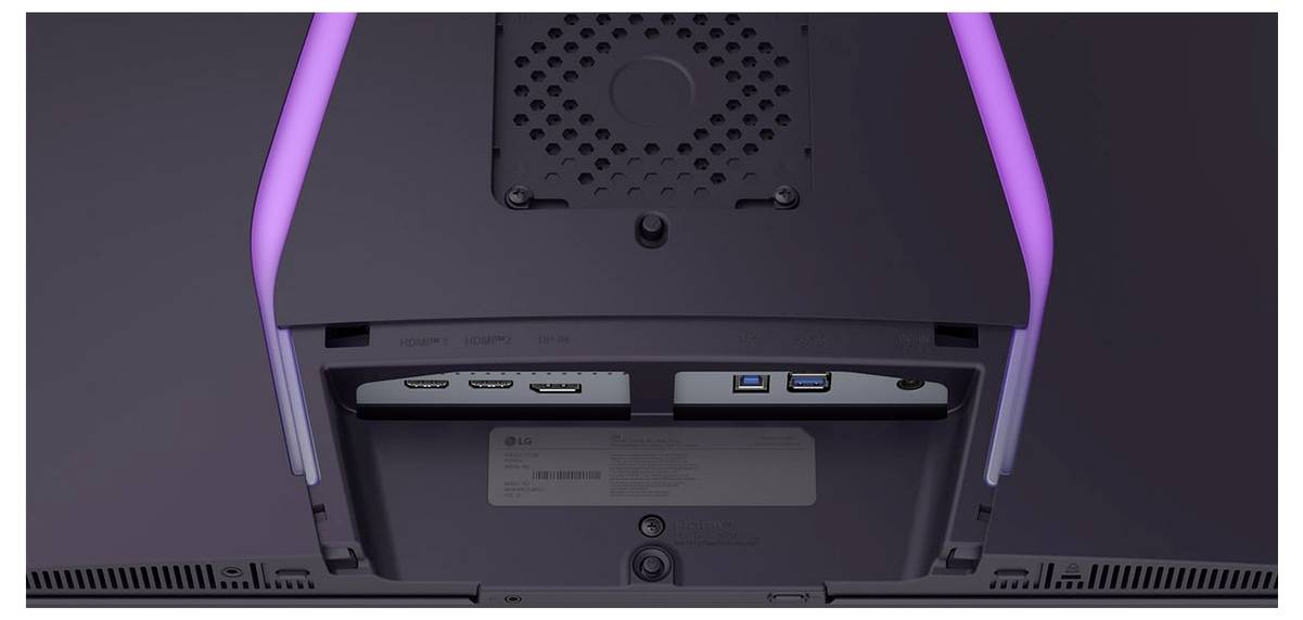Nahaufnahme der Rückseite eines Monitors mit HDMI-, DisplayPort- und USB-Anschlüssen, die durch violette LED-Beleuchtung beleuchtet werden.