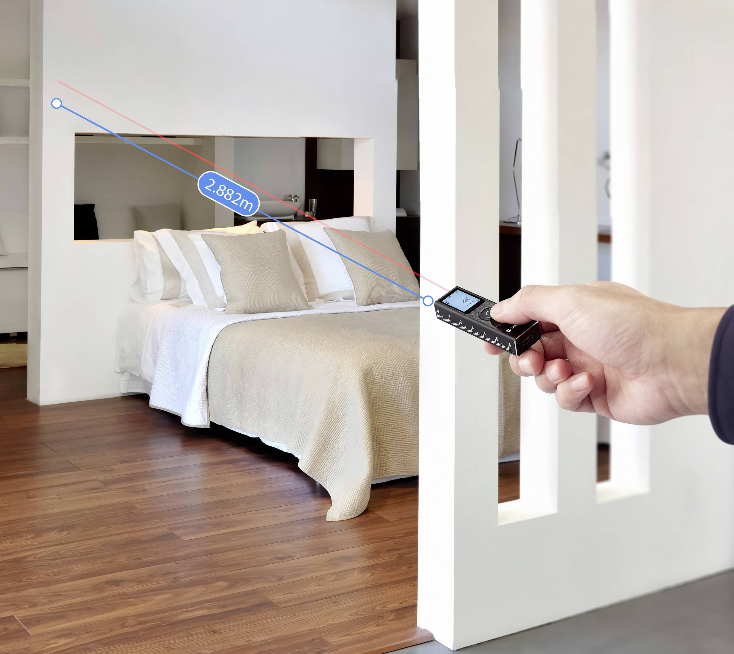 Eine Hand hält ein Lasermessgerät, das auf ein Bett in einem modernen Raum gerichtet ist und eine Entfernung von 2,882 Metern auf dem Display anzeigt.