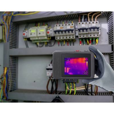 Eine Person verwendet eine Wärmekamera, um eine elektrische Schalttafel zu untersuchen und zeigt dabei Temperaturunterschiede für Wartungszwecke hervor.
