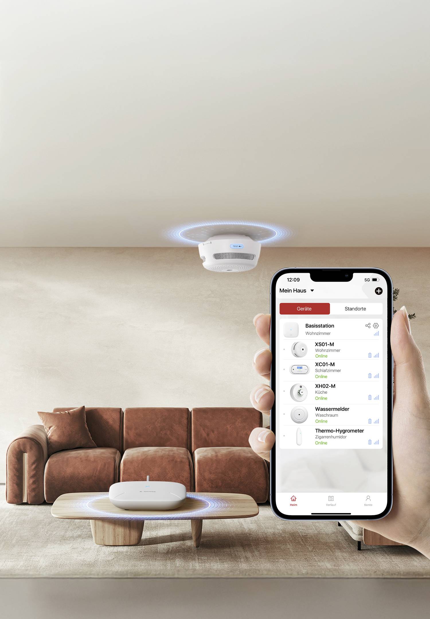 Eine Hand hält ein Smartphone, das eine Smart-Home-App zeigt, die verschiedene Geräte steuert. Ein Rauchmelder ist an der Decke über einem modernen Wohnzimmer montiert.