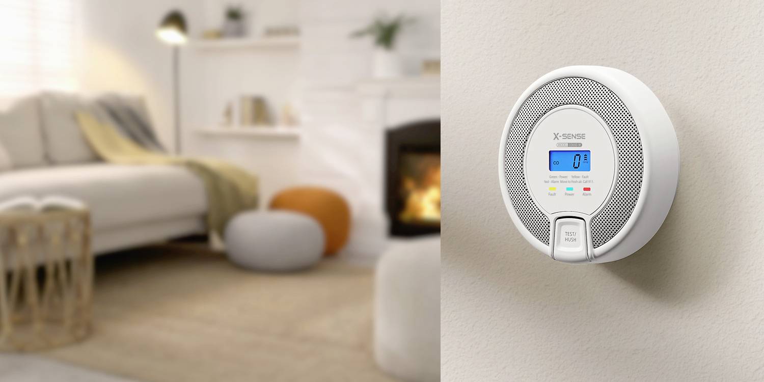 Ein Rauch- und Kohlenmonoxidmelder, der an einer Wand in einem gemütlichen Wohnzimmer montiert ist und einen digitalen Bildschirm mit sichtbaren Anzeigelichtern zeigt.