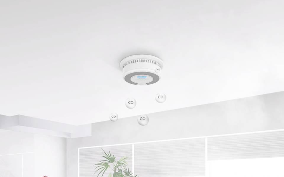 Kohlenmonoxid-Detektor an einer Decke mit schwebenden 'CO'-Etiketten, die die Erkennung von Kohlenmonoxid im Raum anzeigen.