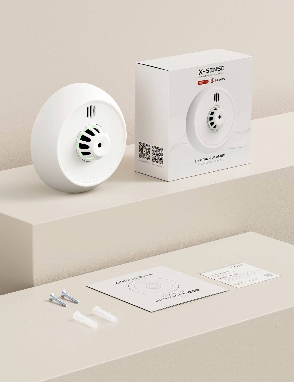 Ein weißer Rauchmelder und seine Verpackung mit der Aufschrift "X-Sense", präsentiert auf einer beigen Oberfläche mit mitgelieferten Installationszubehör.