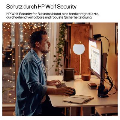 Eine Person an einem Schreibtisch bedient einen Computer, auf dem Sicherheitssoftware angezeigt wird und die 'HP Wolf Security for Business' für robuste Schutzmaßnahmen veranschaulicht.