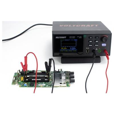 Eine Leiterplatte ist mit einer Voltcraft-Stromversorgung verbunden, die eine Spannungsanzeige und Einstellungen zeigt und auf elektronische Tests oder Reparaturen hinweist.
