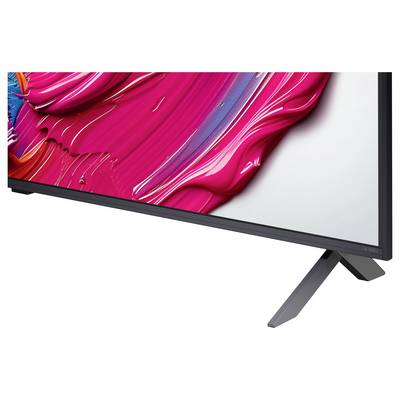 Nahaufnahme eines schlanken, modernen Fernsehbildschirms, der abstrakte Kunst in lebendigen Pink- und Rottönen zeigt, mit einem stilvollen Ständer.