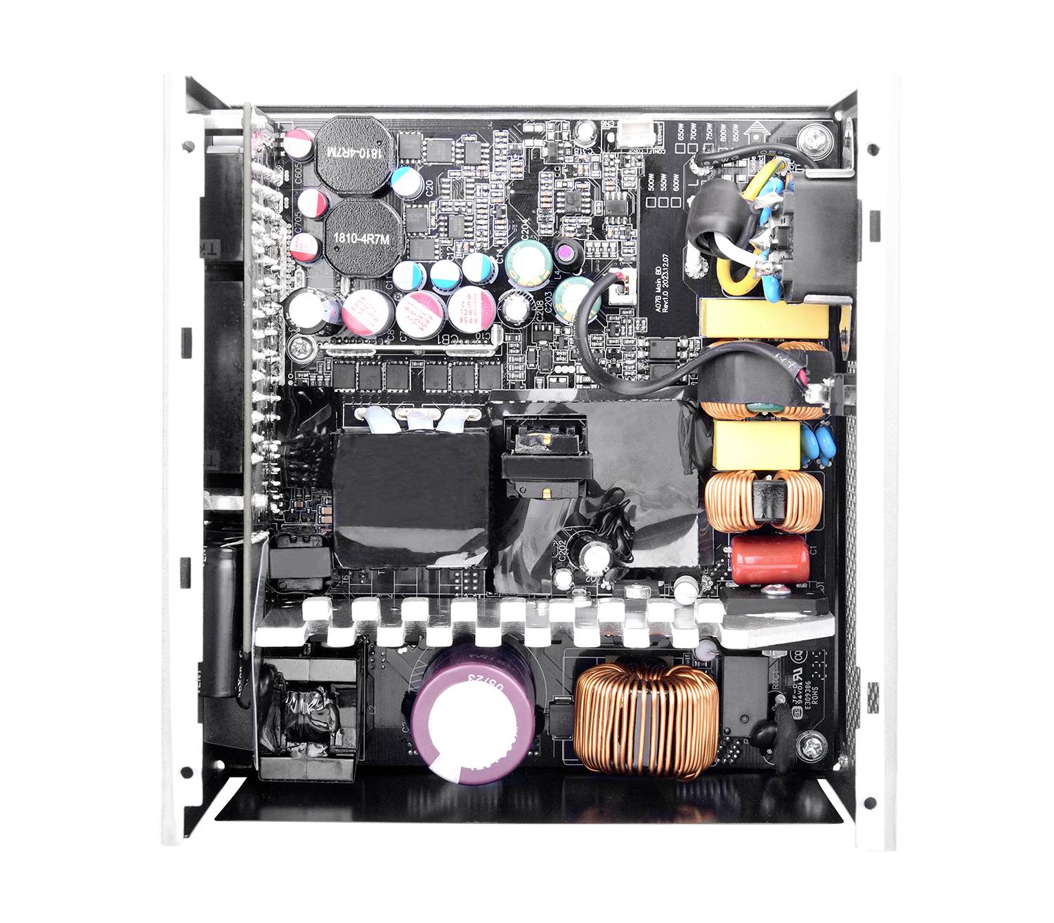 Das Bild zeigt die Innenkomponenten eines Computernetzteils, einschließlich Kondensatoren, Spulen und verschiedener elektronischer Schaltungselemente.