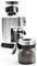 Ein durchsichtiges Gefäß, gefüllt mit gemahlenem Kaffee und mit der Beschriftung "MAX" versehen, befindet sich im Vordergrund. Ein Kaffeemühle mit weiteren Kaffeemöllern steht im Hintergrund.