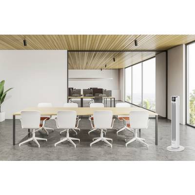 Ein moderner Konferenzraum mit einem langen Tisch, weißen Stühlen, großen Fenstern, einer Zimmerpflanze und einem Standventilator rechts.
