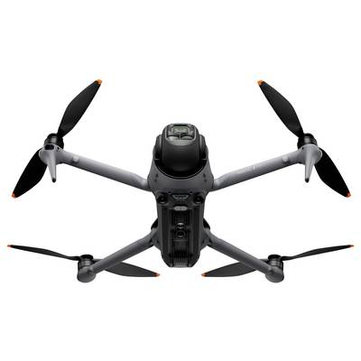 Eine graue Quadcopter-Drohne mit schwarzen Propellern und einer an der Front montierten Kamera, von unten betrachtet, vor einem weißen Hintergrund.