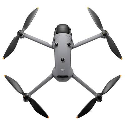 Ein grauer Quadcopter-Drohne mit vier Propellern, von oben betrachtet, der ein kompaktes Design und eine Kamera an der Front zeigt.