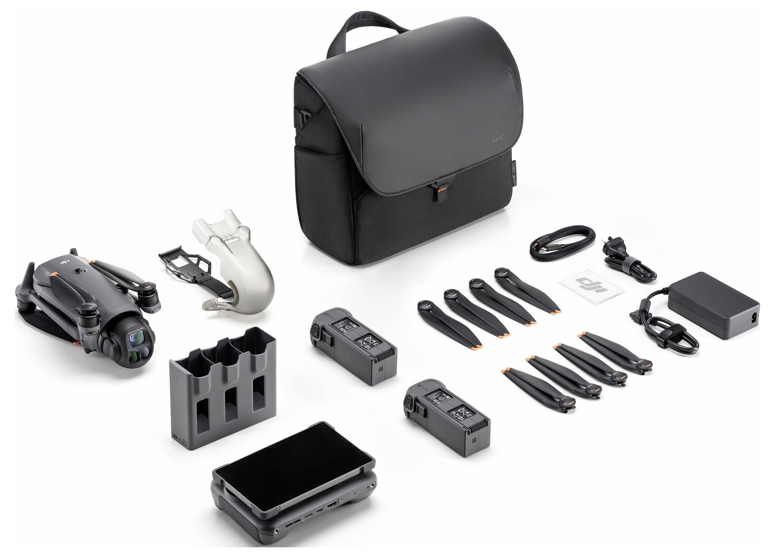 Ein Drohne mit Kamera, zusätzlichen Propellern, zwei Batterien, einem Ladehub, Kabeln, einem Controller und einem Transportkoffer sind auf einer Oberfläche ausgelegt.