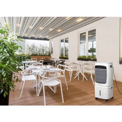 Überdachte Terrasse mit weißen Tischen und Stühlen unter einer Pergola, umgeben von Grünpflanzen. Ein mobiles Luftkühlgerät befindet sich im Vordergrund.