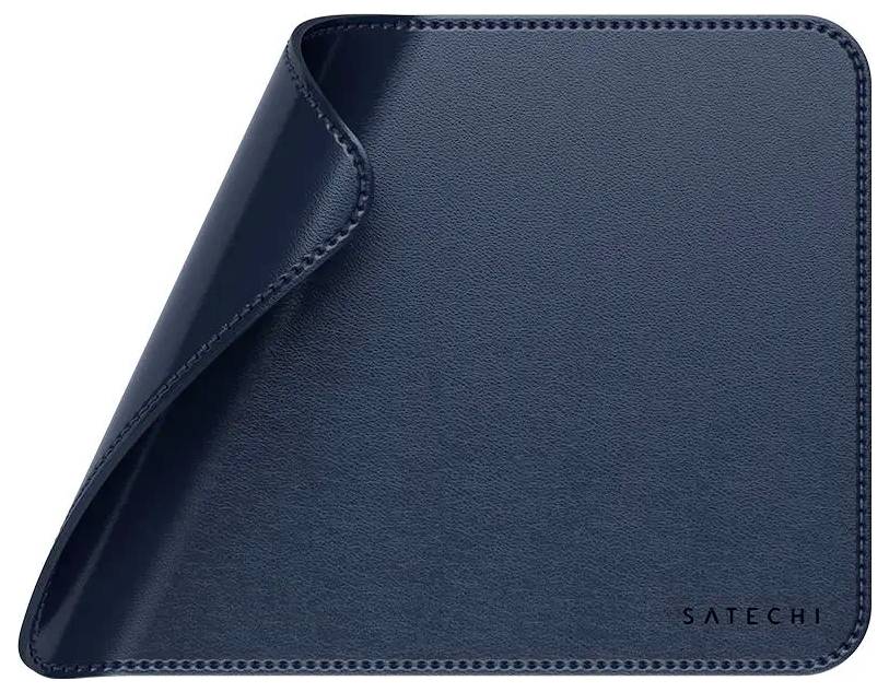 Ein Schreibtischunterlage aus Leder in Marineblau, leicht an der oberen Ecke aufgerollt, mit dem Schriftzug 'Satechi' in geprägter Form in der unteren rechten Ecke.