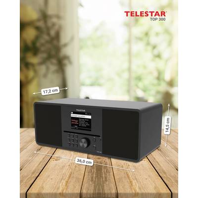 Ein schwarzes Radio der Marke Telestar mit den Maßen 17,2 cm x 36,0 cm x 14,5 cm steht auf einem Holztisch. Im Hintergrund ist ein verschwommener Ausblick.