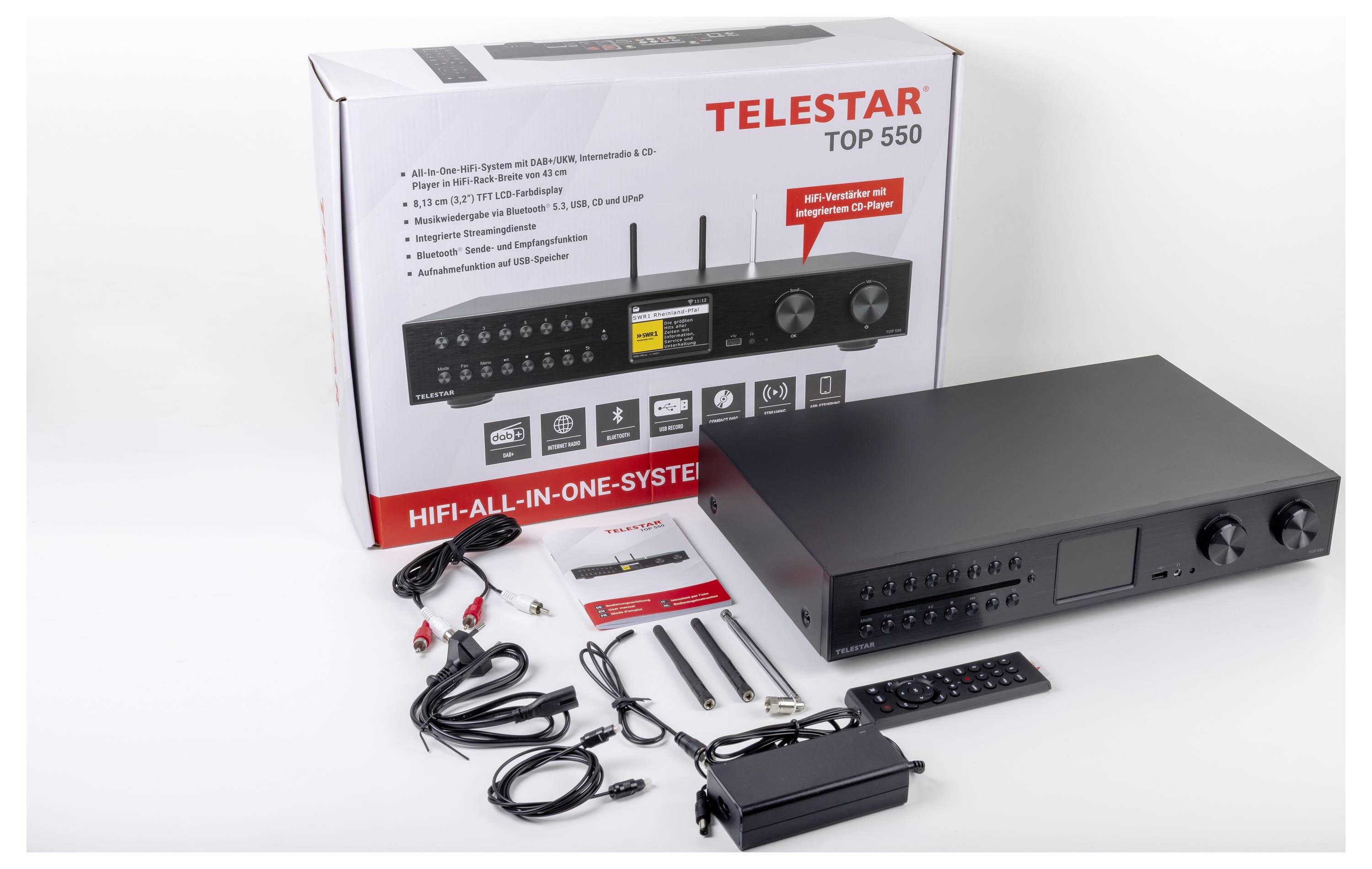 Telestar Top 550 HiFi-Anlage mit Box, Kabeln, Fernbedienung und Zubehör präsentiert. Das System verfügt über ein schlankes, schwarzes Design mit Bedienknöpfen.