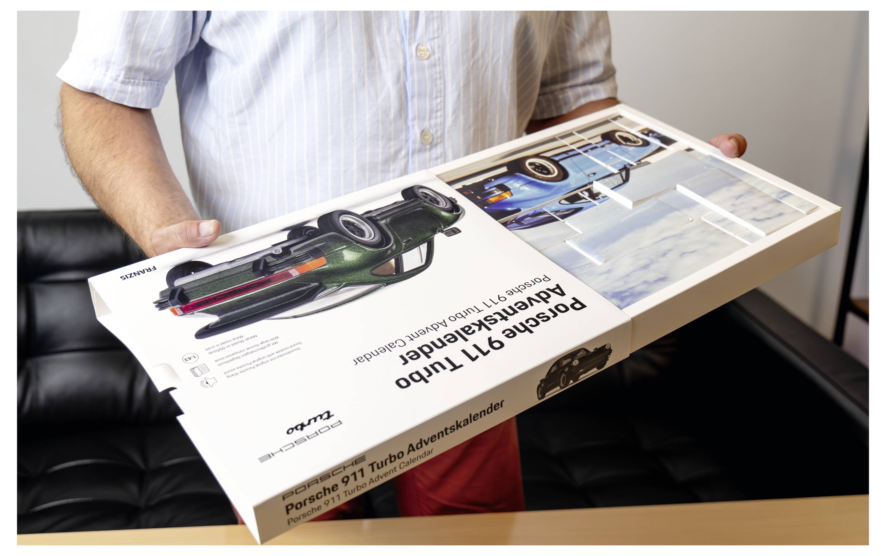 Eine Person hält einen großen Porsche 911 Turbo Adventskalender.
