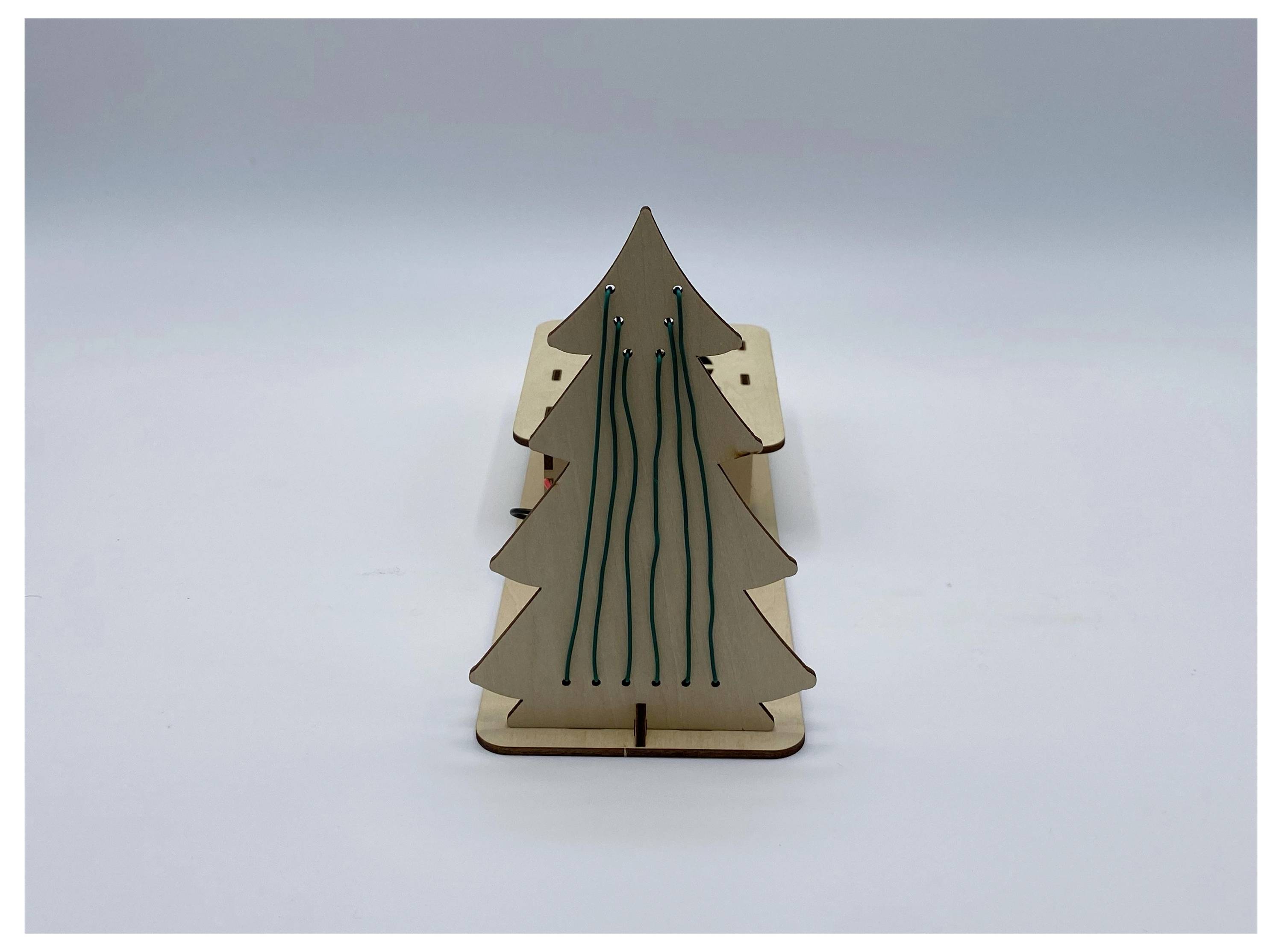 Eine kleine, hölzerne, dreieckige Struktur, die einem Baum ähnelt, mit vertikalen Rillen auf ihrer Oberfläche, die aufrecht auf einer flachen Fläche steht.