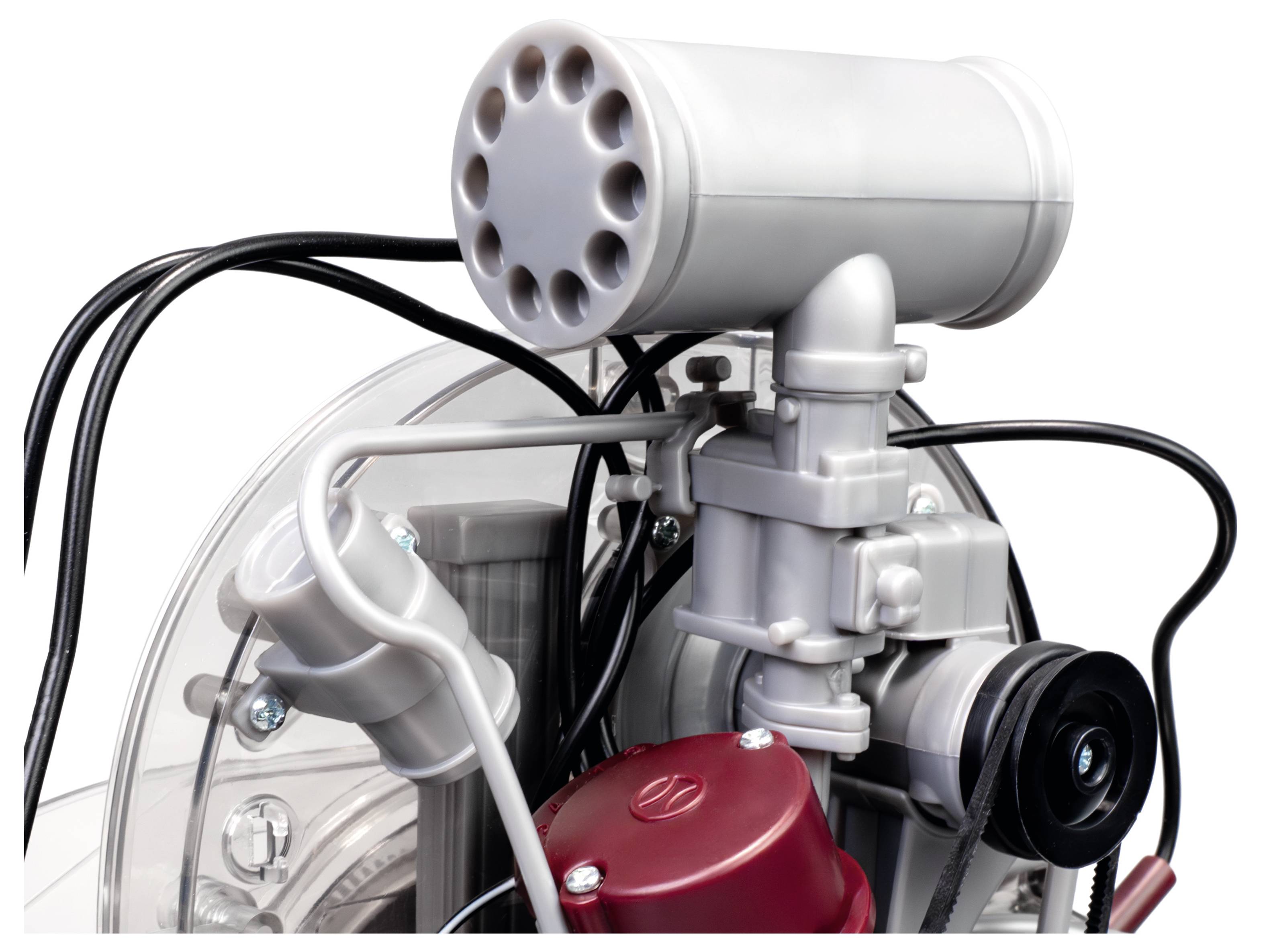 Eine Nahaufnahme eines mechanischen Geräts, die eine zylindrische Komponente mit Löchern, Kabeln und Röhren zeigt, was darauf hindeutet, dass es Teil eines Motor- oder Pumpensystems ist.