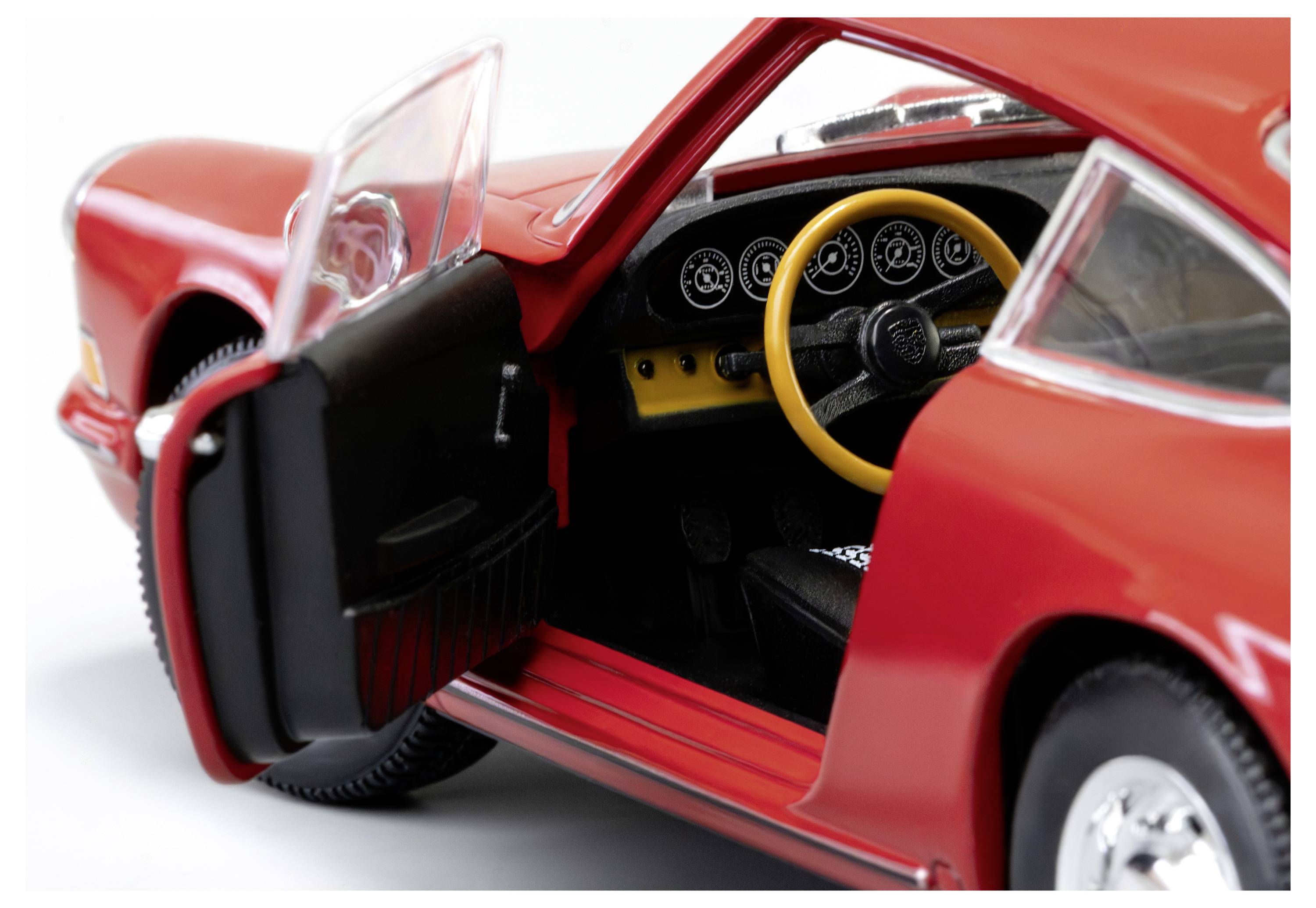 Ein rotes Spielzeugauto mit einer offenen Fahrertür gibt einen detaillierten Einblick ins Innere, einschließlich eines gelben Lenkrads und eines schwarzen Armaturenbretts.